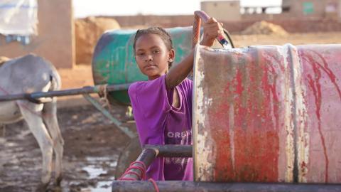 Girl fills barrel with water. Photo: UNICEF/UNI475298/Awad