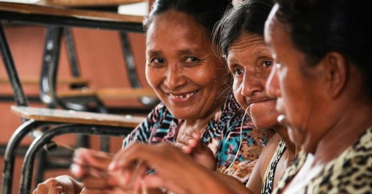 Women seen together, making handicraft.